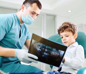 dentist showing child his teeth x ray